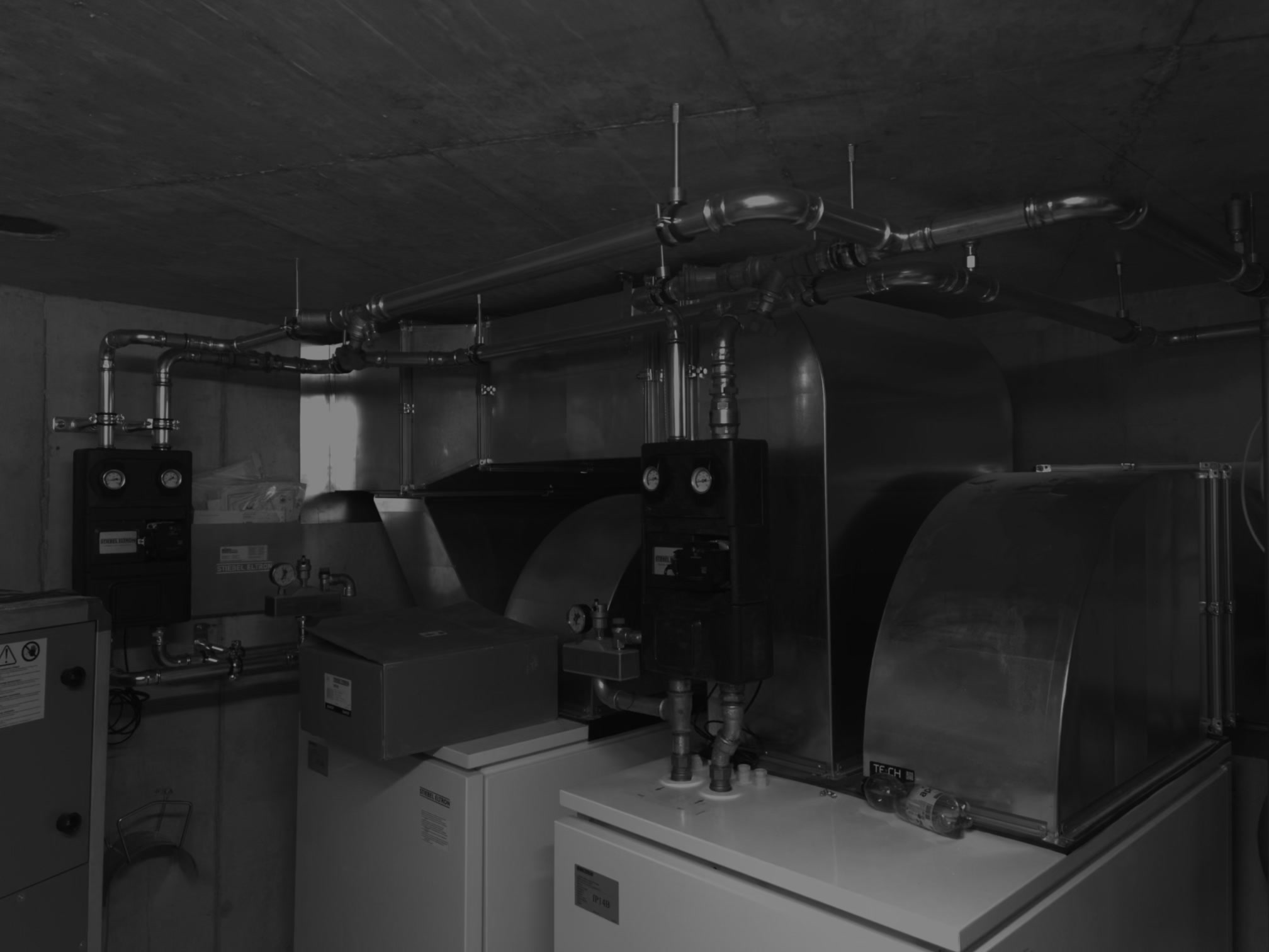 Heizungsanlage Mehrfamilienhaus – Grosse Heizungsanlage mit doppelten Kesseln, Pumpengruppen und kompletter Rohrleitungsführung für ein Mehrfamilienhaus.
