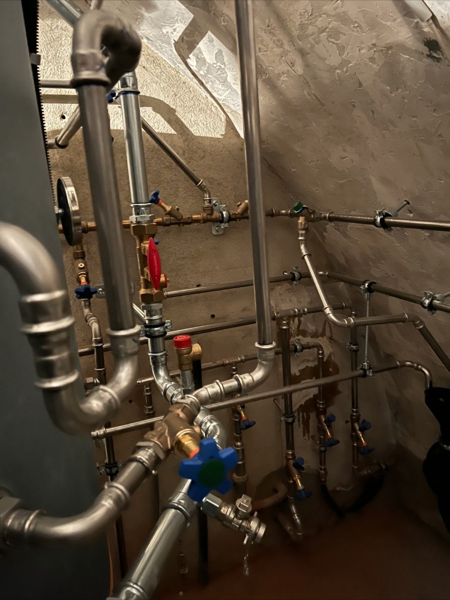 Speicheranschluss mit Pressfittings – Detailansicht der Rohrleitungsanschlüsse am Speicher mit Pressfittings, Absperrventilen und Kugelventilen in Edelstahl.